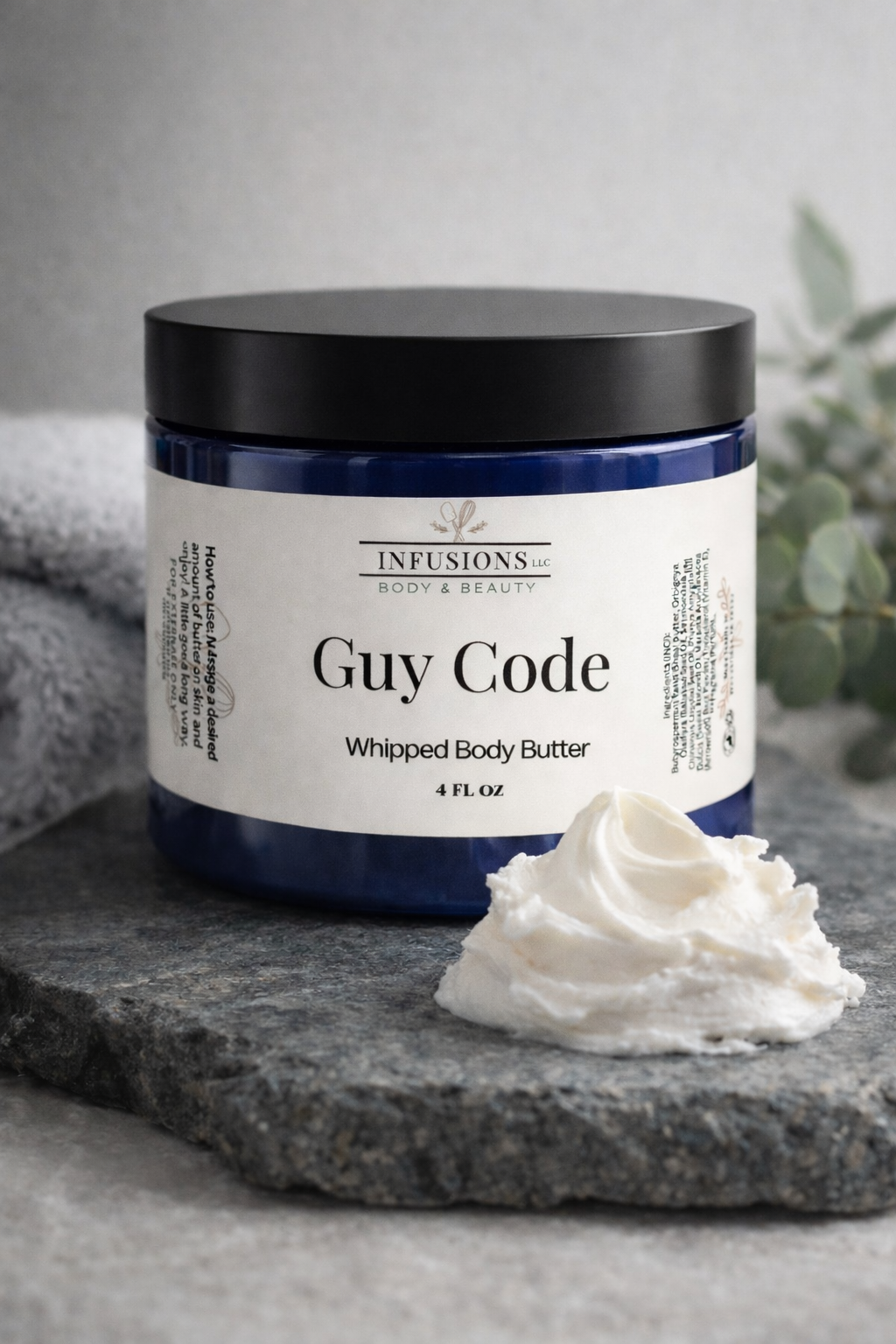 Jar of 'Guy Code' whipped body butter with a dollop on a stone surface.